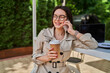 © Тарас Нагирняк - Preety woman speaking by mobile phone and drink coffee to go