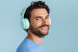 Young brunette man with bristle listening music with headphones