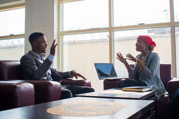 Business meeting. Two business people sitting in front of each other in the office while discussing something.