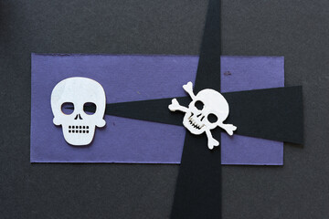 Wall Mural - skull and crossbones on purple and black paper 