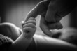 Noworodek trzyma palec w swojej dłoni