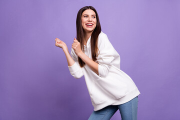 Sticker - Photo of young cheerful positive happy enjoy charming woman look empty space dance isolated on purple color background