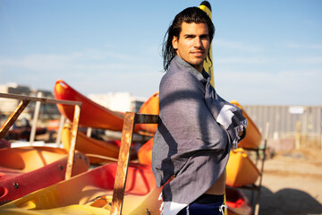 Portrait of handsome surfer with his surfboard. Young man with a surfboard on the beach