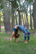 © ADDICTIVE STOCK - Slim female doing Wheel pose in green park in daytime