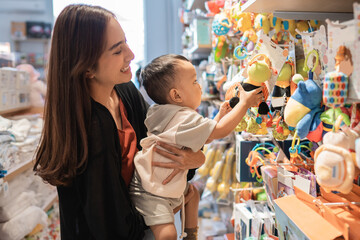 Canvas Print - mother take her 1 year old son to buy toys