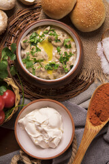 Wall Mural - Top view of delicious mushroom soup and sour cream in clay bowls on a straw trivet in a kitchen