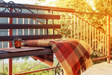 Wall Mural - cup of tea and warm plaid on wooden bench outdoor