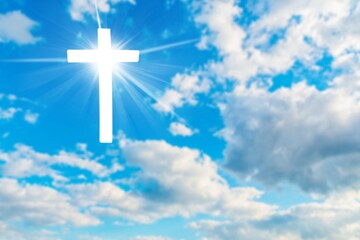 Wall Mural - Christian cross appears bright in the sky background and clouds.