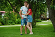 © AS Photo Family - Couple in jeans shorts pose feel love in green grass at courtyard.