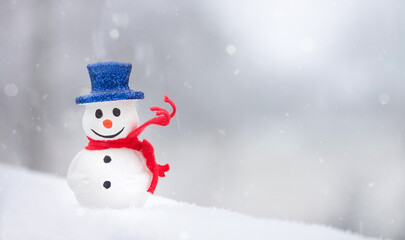  Snowman with red scarf on white snow background. Winter holidays. Christmas time. Copy space. 