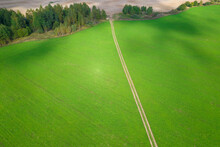 The Road Through A Green Farmer's Field.