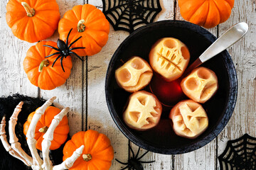 Poster - Spooky Halloween apple head punch. Overhead table scene on a white wood background.