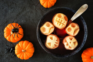Aufkleber - Spooky Halloween apple head punch. Top view table scene on a dark slate background.