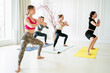 © muse studio - The group is engaged in fitness in the studio. Balance of body and spirit training. A healthy lifestyle. Yoga trainer is an exercise for club clients. The instructor conducts aerobics