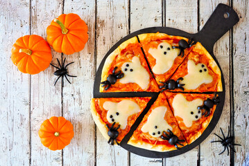 Poster - Halloween pizza overhead table scene on a rustic white wood background