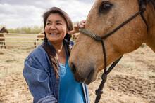 Happy Female Farmer With Horse On Farm