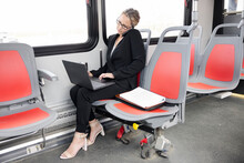 Businesswoman With Laptop And Smart Phone Working On Bus