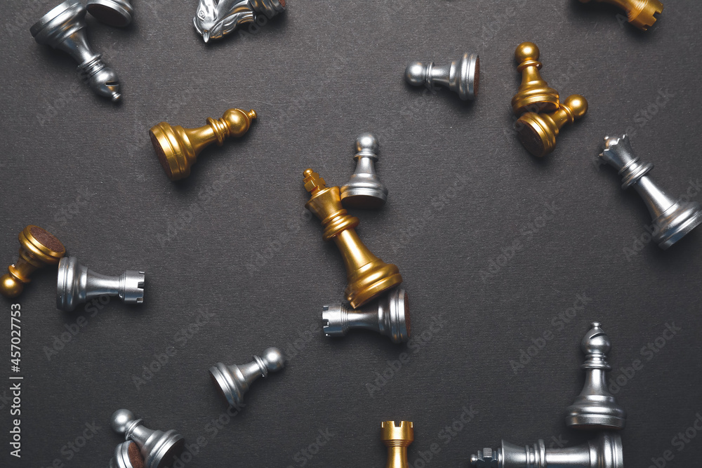 Scattered chess pieces on dark background