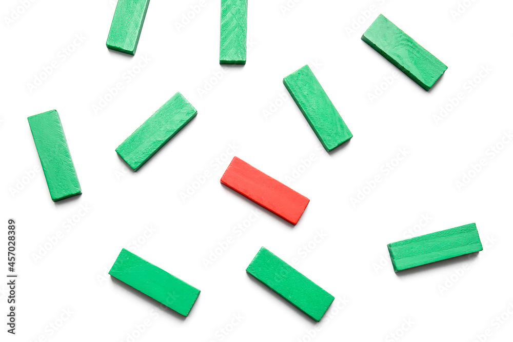 Red block among green ones on white background. Concept of uniqueness