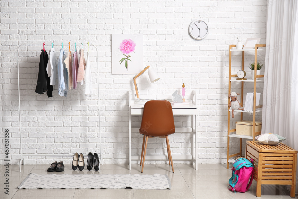 Rack with stylish school uniform in interior of room