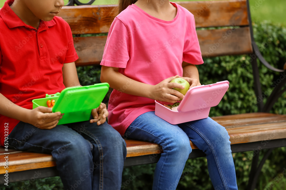 Cute little children having school lunch outdoors