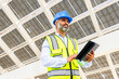 © ADDICTIVE STOCK - Ethnic contractor with tablet standing near solar power station