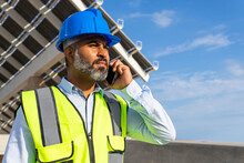 Ethnic Supervisor In Hardhat With Smartphone Against Solar Power Station