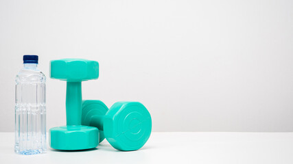 Dumbbell with water bottle on the table white background copy space