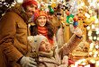 © Syda Productions - family, winter holidays and celebration concept - happy mother, father and little daughter choosing souvenirs at christmas market on town hall square in tallinn, estonia
