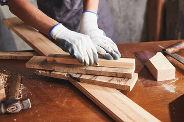 Woman work in wood workshop. Female carpenter working in carpentry shop with pencil drawing sign on plank.