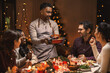 © Syda Productions - holidays and celebration concept - multiethnic group of happy friends having christmas dinner at home