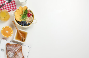 Wall Mural - milk, plate with oatmeal porridge and fruit, freshly squeezed juice in a transparent glass decanter, honey