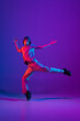 © master1305 - Young stylish man, break dancing, hip-hop dancer practicing solo in casual clothes isolated over purple background in neon pink light at dance hall