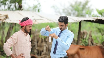 Wall Mural - Indian agronomist or  animal husbandry officer collecting milk sample with farmer at dairy farm 