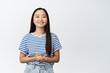 Smiling asian girl looks polite and professional, ready to help and provide assistance, stands against white background