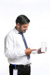 © Niks Ads - Young indian officer showing smartphone screen on white background.