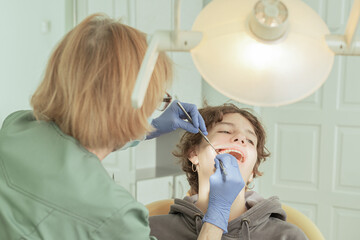 dentist makes an examination of teeth of teenage girl. 