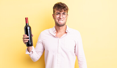 Wall Mural - young handsome man looking puzzled and confused. wine bottle concept