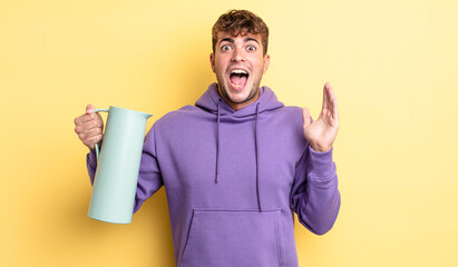 Wall Mural - young handsome man feeling happy and astonished at something unbelievable. thermos concept