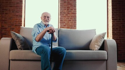 Poster - Cheerful positive relaxed grandpa enjoy sofa rest hold walk cane