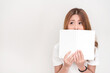 © yaophotograph - Young attractive asian student holding books in her arm on white background. School girl with a books to read for homework.