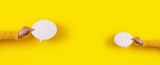 Fototapeta  - two talk bubbles speech icon in hand over yellow background, panoramic layout