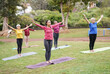 Multi generational women doing yoga exercise at city park - Multiracial people and sport concept
