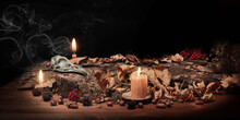 Altar Of Forest Witch. Samhain Pagan Ritual. Birds Skull, Ashberry, Acorns, Dry Herbs, Pine Bark Among Burning Candles In The Dark, Low Key, Selected Focus. Copy Space.