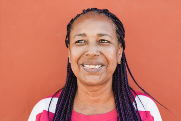 African senior woman smiling with red background