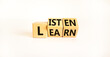 Listen and learn symbol. Turned wooden cubes and chaged a concept word 'listen' to 'learn' on a beautiful white background. Copy space. Business, educational and listen and learn concept.