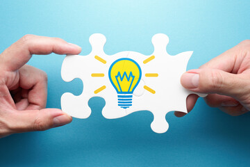 Aufkleber - Inspiration and solution. Two hands connecting jigsaw puzzle pieces. Illustration of light bulb.