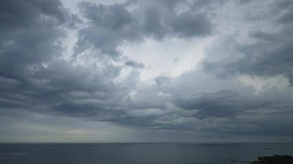 Wall Mural - aerial panning view of dramatic undulating storm clouds rolling across the sky over the water of lak