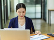 © bongkarn - Asian professional businesswoman working in office, looking at business sale report