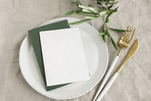 Card Mockup On Modern Minimal Table Place Setting With Cutlery, Olive Branch On Neutral Beige Color Linen Texture Background Top View.  Space For Text. Sheet Card Template, Wedding Invitation, Menu.